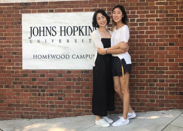 photo with mom in front of the jhu campus